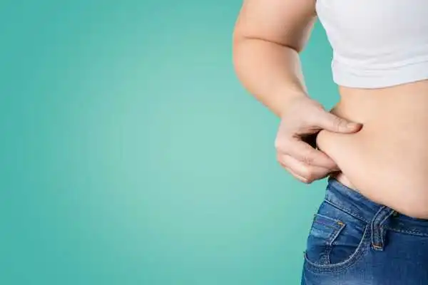 Image of woman pinching her love handles to show weight gain Yeovil